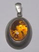 Pendant in 
sterling silver 
with polished 
amber piece 
with seeds. 
Denmark. 20th 
century. 
Stamped ...