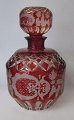 Bohemian 
decanter with 
stopper, 20th 
century. Clear 
glass with red 
overlay with 
cuttings in the 
...