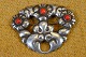 Brooch nouveau, 
flowers, 
sitting in 
silver with red 
glass stones. 
Art No. 9