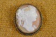 Cameo lady head 
with flowers in 
the hair, cut  
conch, mounted 
in silver frame 
surrounded by 
...