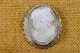 Cameo lady head 
cut off light 
conch in 
scalloped frame 
of gilded 
silver. Mounted 
as a brooch and 
...