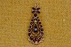 Bohemian Garnet 
Pendant of a 
small flower 
with an eyelet 
at the bottom. 
On it is hooked 
a ...