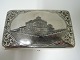 Russian 
cigarette case 
with niello 
work. Richly 
ciselated with 
building on the 
front. Silver 
84 ...