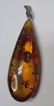 Polished amber 
pendant, 20th 
century. 
Stamped. 
Length: 4 cm.