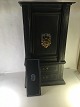 Old unique safe 
in miniature. 
standing on 
wooden shelf. 
with 2 drawers.
gate with lion 
headed ...