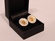 A pair of Daisy 
earclips of 
gilded 925 
sterling silver 
and enamel, 
stamped BH by 
Bernhard ...