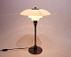 PH 3/2 
tablelamp, 
model Tremp, of 
white opaline 
glass and frame 
of burnished 
brass 
originally ...