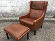 armchair in 
leather with 
footstool. From 
approx. 1970, 
with nicely 
patinated 
leather.