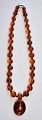Neck chain with 
round amber 
pieces. With 
older brooch of 
amber. 20th 
century. Chain 
length: 42 ...