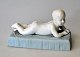 Bisquit figure 
of lying naked 
boy, 19th 
century 
Germany. On 
plinth of light 
blue bisquit. 
...