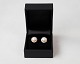 Set of earrings 
of 18 carat 
gold with pink 
cultured pearls 
circled by 21 
smaller 
diamonds.
