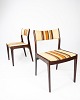 A pair of 
chairs in dark 
wood, 
upholstered in 
lightly striped 
fabric, 
showcase the 
elegant ...