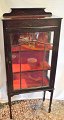 English display 
cabinet with 
tapered legs, 
approx. 1900. 
With carved 
flowers. With 
two shelves. 
...