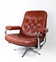 An armchair 
upholstered in 
red leather and 
with a metal 
frame, of 
Danish design 
from the 1960s, 
...