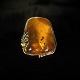 A gold ring set 
with amber, 
mounted in 14 k 
gold. 
Ring size 52. 
Amber: height 
3 cm. width ...