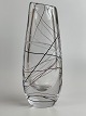 Swedish vase of 
clear glass 
with white, red 
and black 
thread and 
slanted top. 
The vase was 
...