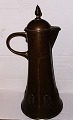 Jug in hammered 
copper 
&#8203;&#8203;with 
handle and lid. 
Decorated at 
the bottom with 
organic ...