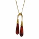 A long necklace 
in 14k gold, 
set with two 
carnelians. 
Necklace l. 50 
cm. 
Pendant l. 5,5 
cm. ...