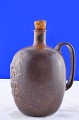 Arne Bang 
stoneware, jug 
with handle, 
with text CLOC 
CACAO, 
decorated in 
brownish glaze, 
height ...