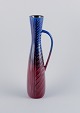 Carl Harry 
Stålhane for 
Rörstrand. Tall 
and slim 
ceramic pitcher 
in blue and 
burgundy ...