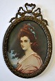 Miniature 
painting of a 
woman, 
19th/20th 
century. In 
oval bronze 
Louis XVI style 
frame with bow. 
...