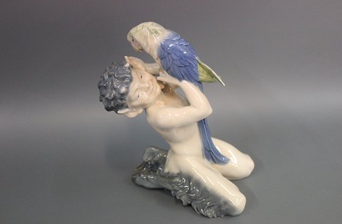 Royal Copenhagen porcelain figurine, Faun sitting with a parrot, no. 752. 
The figurine is from 1964. 
5000m2 showroom.