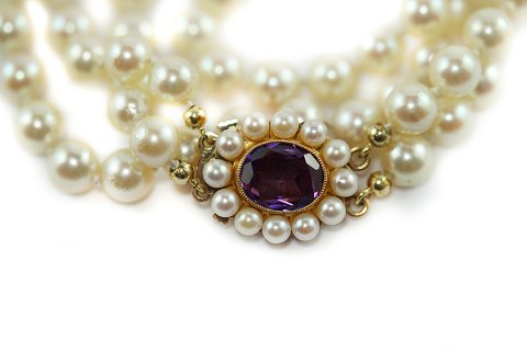 A pearl necklace with an amethyst clasp of 14k gold
