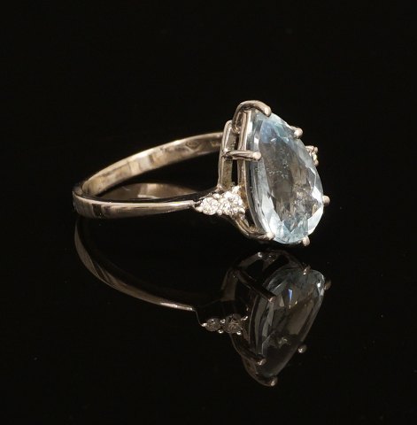 18kt hvidguld ring med akvamarin flankeret af fire 
diamanter. Ringstr. 56