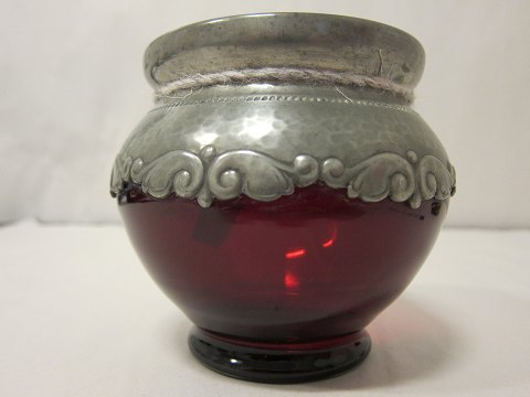 Vase made of rubin red glass with  pewter
This beautiful antique rubin red vase made of glass is with a decorative pewter 
in the Jugend / Art Nouveau still.
The pewter has a stamp: "TB".
About 1910
H: 11cm, W:12cm