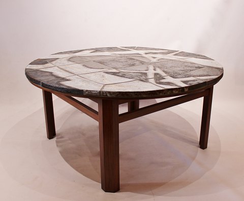 Large round coffee table with stone plate and frame of rosewood, danish design 
from the 1960s.
5000m2 showroom.