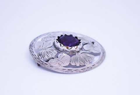 Round brooch of 830 silver and with large purple synthetic stone.
5000m2 showroom.
