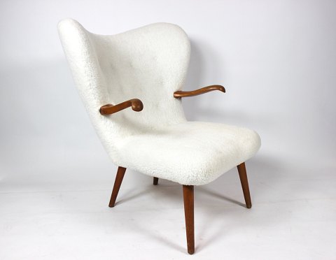 Hvilestol polstret med fåreuld og med arme af mørkt træ af dansk design fra 
1930erne. 
5000m2 udstilling.