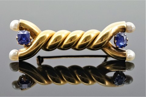 A sapphire brooch mounted in 14k gold set with pearls