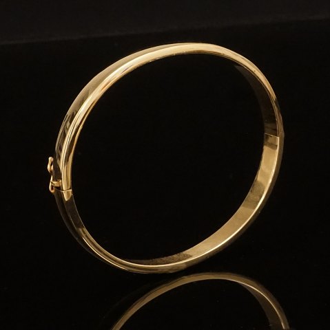 A oval gold bangle of 14kt gold. Size inside: 
5,3x6,0cm