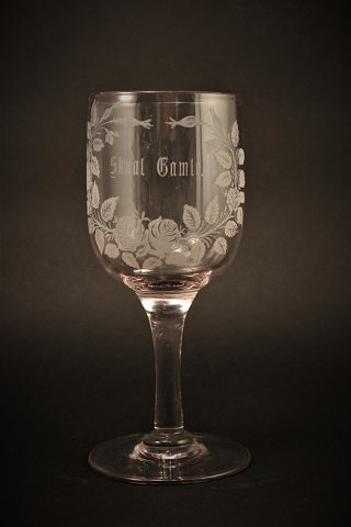 Gammelt erindrings glas fra Holmegaard glasværk med 
fine graveret blomster dekorationer og skrift "Skaal Gamle"
H:17cm. Dia:7cm.