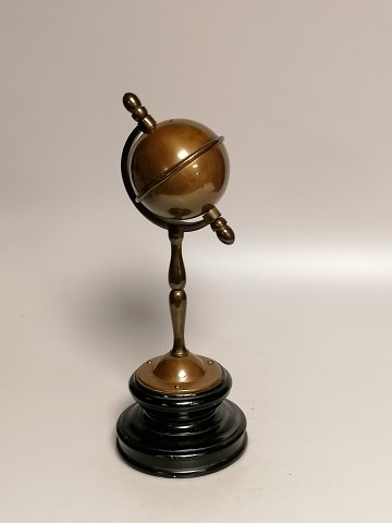 Patinated brass money box in the form of a globe on a wooden base