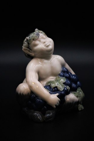 Royal Copenhagen porcelain figure of small pan figure with the arms full of blue 
grapes. RC# 2361.
Height: 13.5cm.