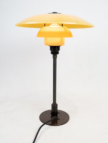 PH 3-1/2 2-1/2  patented. Bordlampe med bruneret metal stel og gul mat opal 
skærme med gennemgående afbryder fra år 1933. 
5000m2 udstilling.

