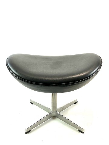 Foot stool for the Egg, model 3127, upholstered in black elegance leather, 
designed by Arne Jacobsen in 1958 and manufactured by Fritz Hansen in 1998.
5000m2 showroom.
Great condition
