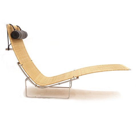 Poul Kjærholm PK 24 chaiselong / Hammock chair med 
peddigrør og stel i rustfrit stål. Nakkepude i 
sort læder. Produceret af Fritz Hansen. Design fra 
1965. H: 88cm. L: 150cm. B: 69cm