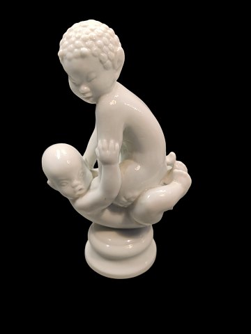 Sjælden Dahl Jensen figur. Blanc de chine. Faun siddende på baby. Modelnummer 
1038.
Måler : 13 cm x 7,5 cm.