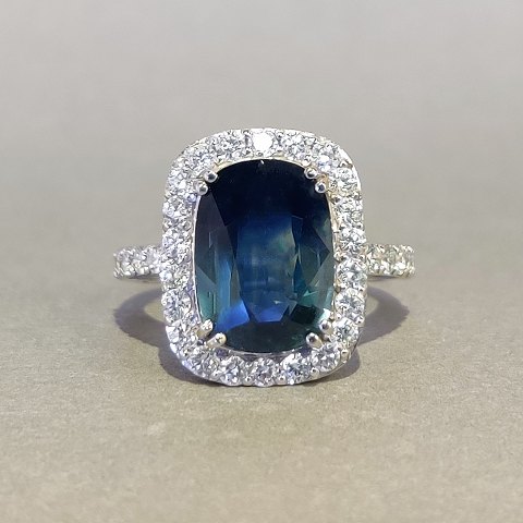 A sapphire ring with diamonds mounted in 18 kt. white gold