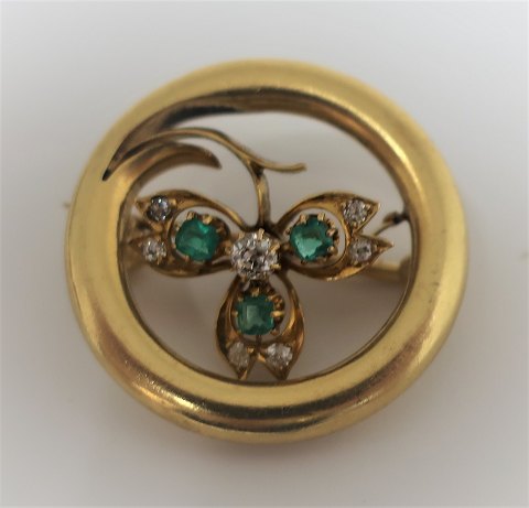 Gold brooch 18K. Not stamped. Presumably Norwegian. With 3 emeralds and 7 small 
diamonds. Diameter 25 mm