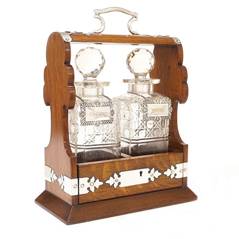 Tantalus in an oak box with two decanters. England 
circa 1880. H: 33cm. W: 25cm. D: 14cm