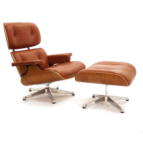Eames loungechair med skammel designet 1956. 
Polstret med rød/brunt læder i pæn stand. Under 
sæde plakette fra producenten. Stol: H: 90cm. B: 
84cm. D: 70cm