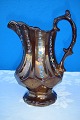 English 
pitcher, copper 
colored luster 
decorated with 
flowers, height 
17 cm. Fine 
condition