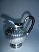 Milk jug in 
ribbed silver 
with ebony 
handles 
complimented 
with a duck 
head, Denmark 
approx. ...