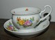 Cup and saucer 
in porcelain 
with high 
handle. Painted 
with flowers. 
Saucer with 
high edge. ...