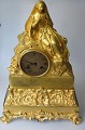 French flame 
gilded mantel 
clock, c. 1820. 
empire. A 
sitting young 
woman on a 
stone. Base 
with ...