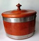 Butter 
container. In 
teak, app. 
1950. With lid. 
A strip of 
steel. H .: 23 
cm. Dia .: 25 
...